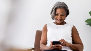 bxblue - mulher negra, utilizando celular, pesquisando online - pagamento do inss atrasado, regularização