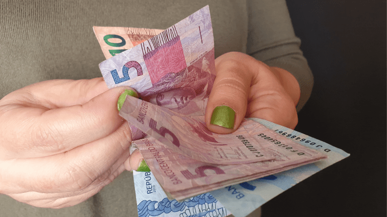 bxblue - banco para receber a aposentadoria - mulher com dinheiro nas mãos, contando, receber pagamento