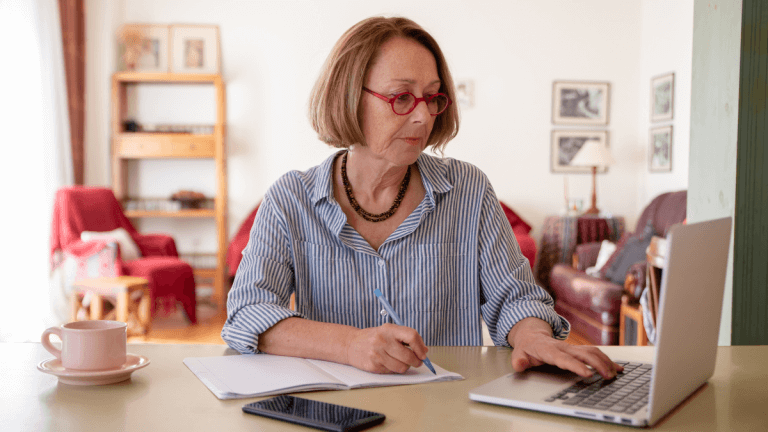 bxblue - data de cessação do benefício - mulher branca de óculos, pesquisando usando computador e fazendo anotações
