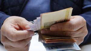 bxblue - homem contando dinheiro nas mãos - empréstimo consignado no Agibank - banco online INSS