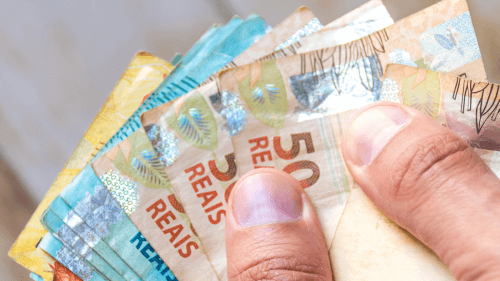 décimo terceiro salário INSS 2021 - pessoa com cédulas de dinheiro na mão