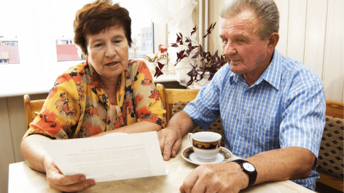 número final do cartão de benefício INSS - homem e mulher avaliando documento, com papel nas mãos