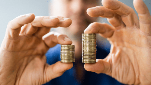 ofertas de empréstimo consignado - pessoa com duas pilhas de moedas nas mãos, comparando