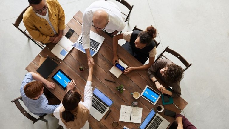 impactagov - mesa de reuniões com pessoas trabalhando