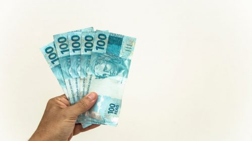 margem do consignado 2021 - mão segurando notas de real brasileiro
