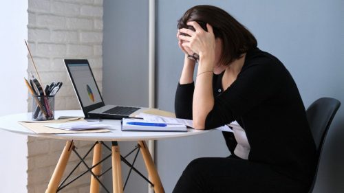 benefício cessado - mulher preocupada em frente ao computador