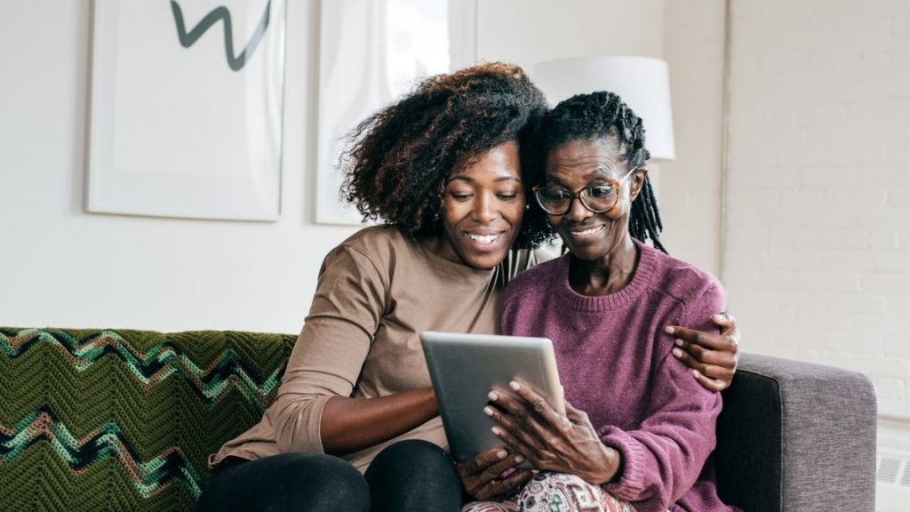 bxblue - mulheres negras sentadas no sofá utilizando o tablet, online, pesquisando - como funciona o empréstimo consignado online