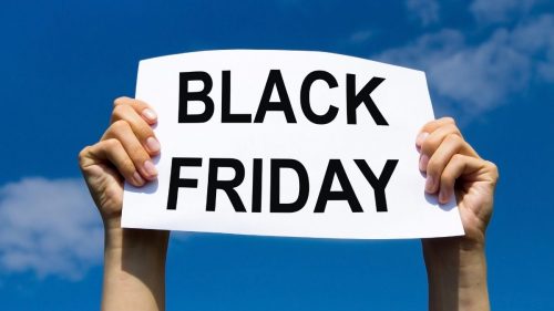 golpes de empréstimo consignado na black friday - pessoa segurando cartaz de anúncio da black friday