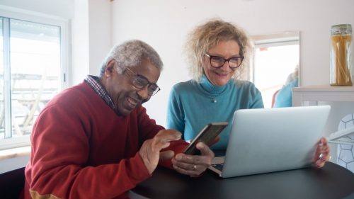 bxblue - homem e mulher de terceira idade, utilizando computador e celular, sorrindo - previdência social, regras