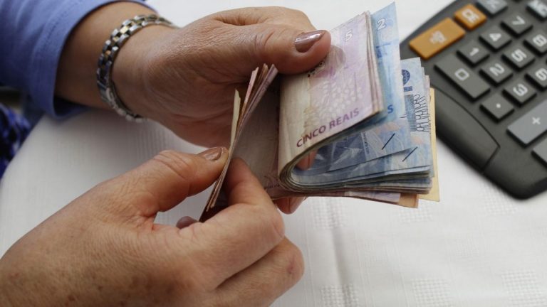 empréstimo consignado no banco safra - pessoa contando notas de dinheiro em real brasileiro