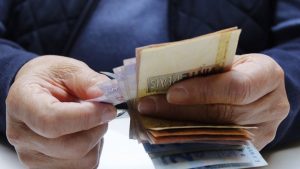 tipos de saque do fgts - mãos contando notas de dinheiro em real brasileiro